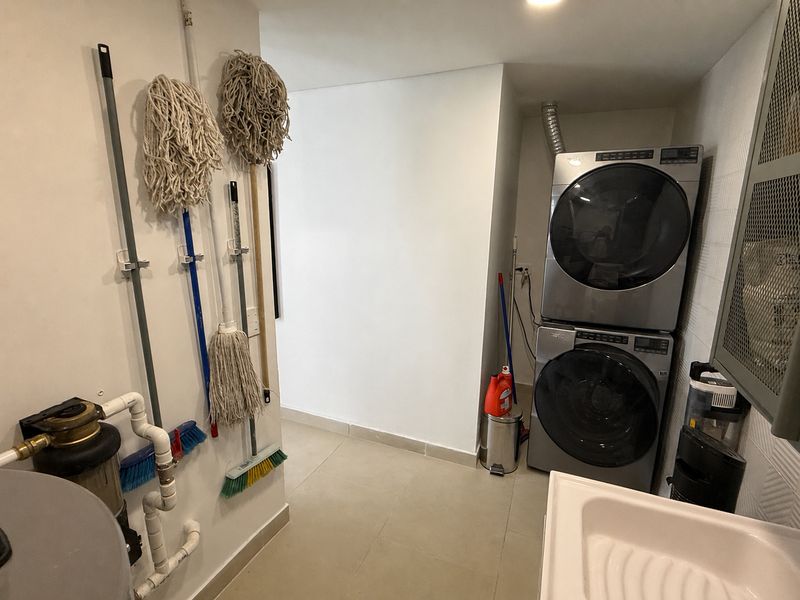 Cuarto de ropas con lavadora, secadora y almacenamiento